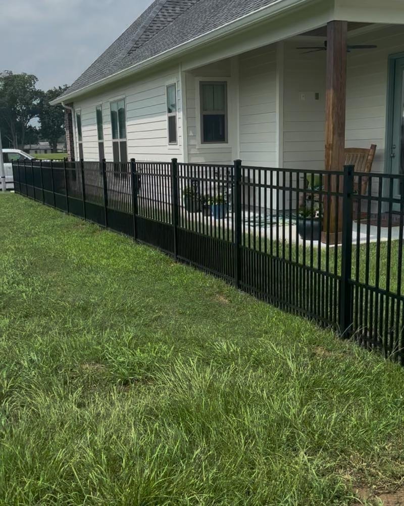 Black metal fence around the front porch of a new home
